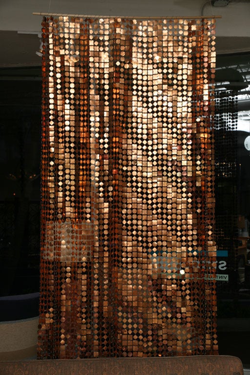 Plasticized metallic squares, circles, and diamonds in copper and gold are linked to create a subtle ombre stripe in this very special Paco Rabanne space curtain.